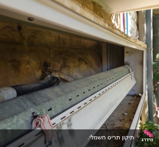 מנגנון תריס גלילה פתוח בתוך ארגז תריס במהלך עבודת תיקון